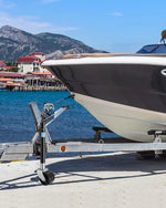 Boat on a trailer wheel jack at a dock with mountains